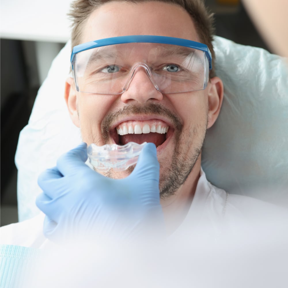 A man is getting fitted for a custom mouth guard.